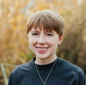 Sarah Gerton A smiling woman with short blonde hair and a gray shirt