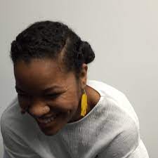 Erika in a white shirt and yellow earrings, laughing